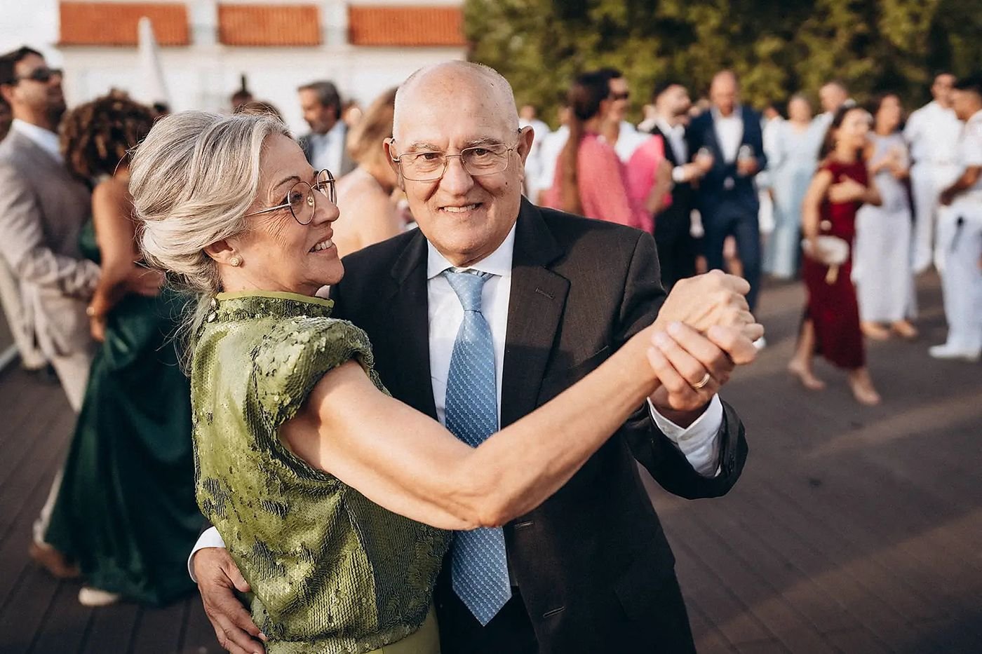 Casal de avós a dançar ao ar livre, sorridentes