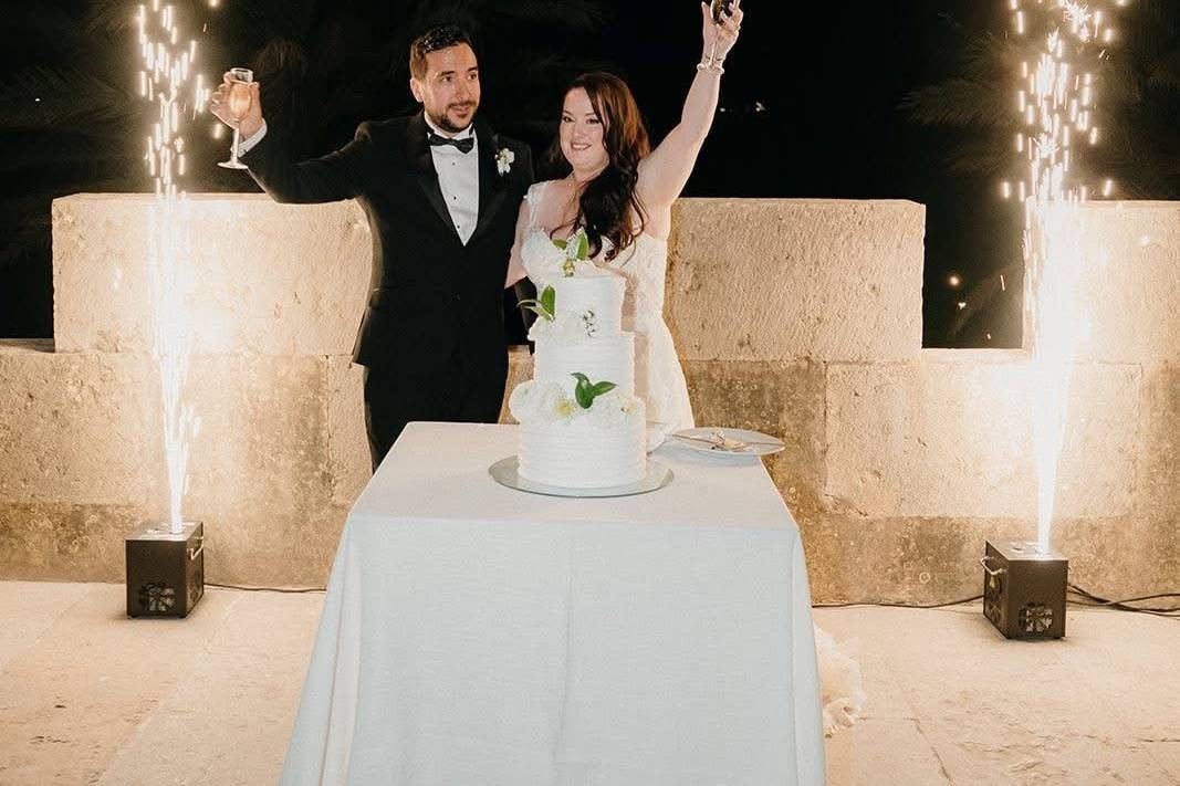 Casal de braços no ar entre duas colunas de fogo frio